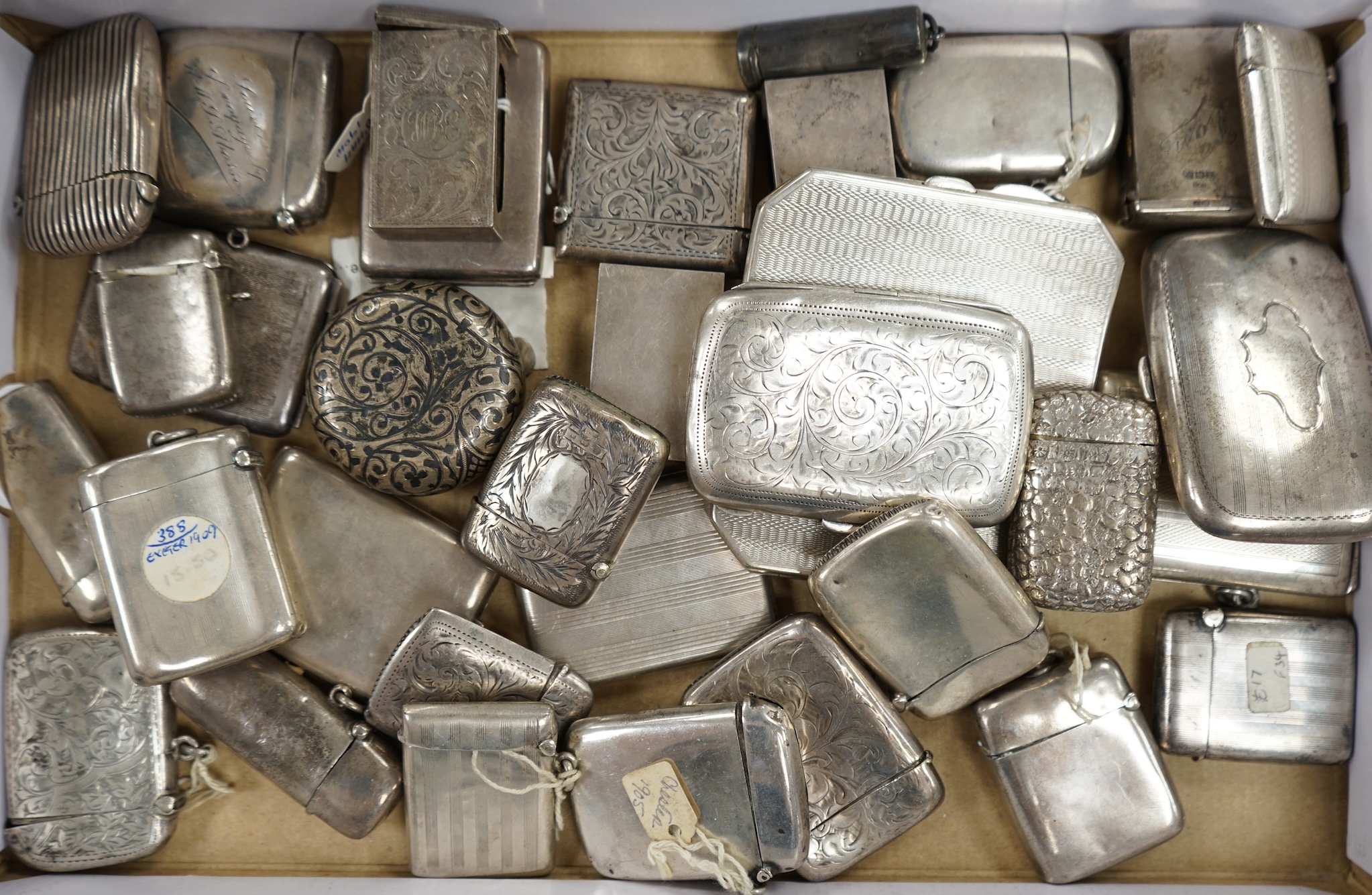 A collection of twenty four assorted silver vesta cases, eight cigarette cases, two match sleeves and a late 19th century Russian 84 zolotnik niello small tobacco box. Condition - poor to fair